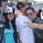 Three figures in a group pose with one figure in a white shirt and blue cap, another in a white shirt, and the third in a blue dress, all with pixelated faces and dark hair.