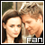 Static pixelated image of two people in close proximity with a 'FAN' logo at the bottom right, likely from a television show or fandom context.