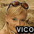 A woman in a yellow bikini top with pink trim lies on a sandy beach, wearing sunglasses on her head and a pearl necklace, with text overlays reading "VICO" and "PAZ".