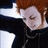 Pixelated image of a character with red hair and closed eyes, wearing dark clothing against black background with red text.