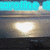 A pixelated image shows a bright light source over water with text at the top, transitioning from cyan to white.