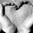 Black-and-white pixelated image of a person's face with hands near the mouth, next to bright pink background with repeated white text.
