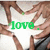 A pixelated image shows multiple hands forming a circle around green text reading 'love.' on a white background.