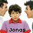 A pixelated image of a person in a purple shirt with red collar and sleeves, with text overlays reading 'Jonas', 'Brothers', and '= my LIFE' across different sections.