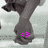 A pixelated image of a person's lower legs and feet in dark pants, with a bright pink '<3' symbol on the left foot against a light background.