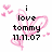 Pixelated icon with black text 'i love tommy 11.11.07' overlaid on pink heart-shaped lines and scattered hearts.