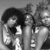 Black-and-white animation of three figures in a group pose with shifting facial expressions and body angles across frames.