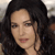 A static pixelated image shows a person with long dark hair, light skin, and visible facial features including eyes, nose, and lips.
