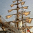 Pixelated static image of a ship with multiple masts and sails against a light blue sky background.