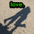 Pixelated image with 'love.' text above a dark silhouette on beige background, transitioning to heart symbols and text elements.