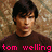 A person with dark hair and a brown shirt appears in multiple views against a textured background, with pink text reading "tom welling" below.