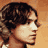 Pixelated static image of a person's profile with curly dark hair against an orange background, rendered in low-resolution 256x256 pixels.