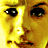 Pixelated close-up of a human face with yellow and brown tones, featuring large eyes, visible nose, mouth, and eyebrows on a bright background.