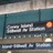 Pixelated static image showing a stylized 'EST' logo with metallic silver letters on dark background, orange circular element to the right, and horizontal lines below.