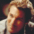 A pixelated image of a person with light brown hair holding a microphone, next to green text reading 'Original Icons .com' on a dark background.