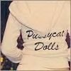 A person wearing a light-colored long-sleeve shirt with dark text reading 'Pussycat Dolls' on the back, viewed from behind.