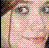 Pixelated close-up of a person's face with light skin, green eyes, and brown hair against a checkered background.