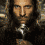 A pixelated image of a man with long dark hair and beard, wearing dark clothing and holding a silver helmet, next to text reading "LORD OF THE RINGS" in gold lettering.