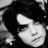 Pixelated grayscale image of a stylized face with closed eyes and a slight smile, set against a dark background with lighter abstract shapes.