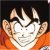 Pixelated static image of a character with spiky black hair, orange clothing, and a smiling expression against a dark background.