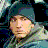 Pixelated static image of a person's face with teal hair and light skin tones against dark background, rendered in low-resolution 256x256 pixels.