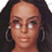 Pixelated static image of a person's face with dark hair and hoop earrings, displayed on a transparent background.