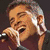 A collage of five distinct visual elements including a person singing into a microphone, red text fragments, and the X Factor logo.