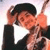 A person in a black suit and white shirt holds a violin and bow, with hands positioned to play music.