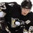 A pixelated image shows a person in dark clothing with a light-colored emblem on the chest, next to yellow text reading "Sidney Crosby #87" on black background.