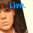 A pixelated image of a person with brown hair and bangs, wearing a white top, with blue text above the head reading 'Live.'