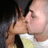 Two people in close proximity, one with dark hair and light skin, the other with light hair and light skin, sharing a kiss in a pixelated animation.