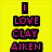 Yellow background with pink and black text reading "I LOVE CLAY AIKEN ON MY WAY HERE MAY 6 2008" next to a person speaking at a microphone.