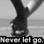 Black-and-white pixelated image of a hand holding a microphone with text "Never let go." at the bottom.
