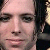 Pixelated close-up of a person's face with light skin tone, dark eyebrows, and dark hair visible on the right side, set against a light background.