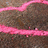 Pixelated static image with two horizontal pink lines on a brownish-gray background, no visible text or distinct subjects.