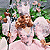 Pixelated image of two figures in white lab coats holding a brown dog-like animal against a green and pink background.