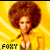 A pixelated image of a person with an afro hairstyle wearing a yellow jacket over a green top, set against a bright yellow background with radiating lines.