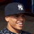 A pixelated close-up of a person wearing a dark blue cap with a white 'NY' logo, showing partial facial features and a patterned shirt.