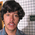 A pixelated image of a person with dark curly hair and a mustache, wearing a blue shirt against a checkered background, next to text reading 'vote 4 pedro' in bold black letters.