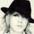Pixelated static icon of a person with long light-colored hair wearing a dark wide-brimmed hat, face partially obscured by the brim against a plain background.