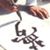 A pixelated icon shows a hand holding a calligraphy pen above stylized Arabic script on white background.