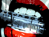 Red lips with white teeth hold a silver syringe with black markings; the syringe's plunger shifts position across frames.