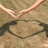 A pixelated image shows a light brown curved shape above a dark brown oval shape on a beige background.