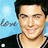 Pixelated image of a person with dark hair and light skin wearing a black jacket over a white shirt, set against a blue background with partial text.