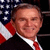 Static 50x50 pixel icon showing a man in formal attire with an American flag background, rendered at low resolution with visible dithering and pixelation.