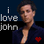 A pixelated image of a person in a dark blue shirt with text 'i love john' and two red hearts, one above the head and one below.