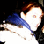 A person with reddish-brown hair and blue scarf wears a white jacket, shown in three where the head turns slightly right then left