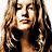 A pixelated image of a woman in a bikini top and bottoms, with visible text 'Coolbuddy.com' on a beige background.