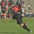 A football player in a black uniform with red number 18 runs on a grass field, captured across three showing motion progression