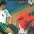 Pixelated static image of two soccer players in action poses on a field background with blue sky and green grass elements.